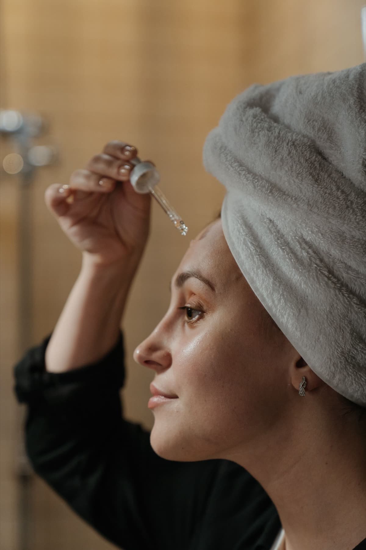 A person applying serum during a quiet skincare ritual